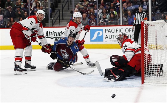 Carl Soderberg z Colorada padá mezi dvojicí Jordan Staal (vlevo) a Trevor van...