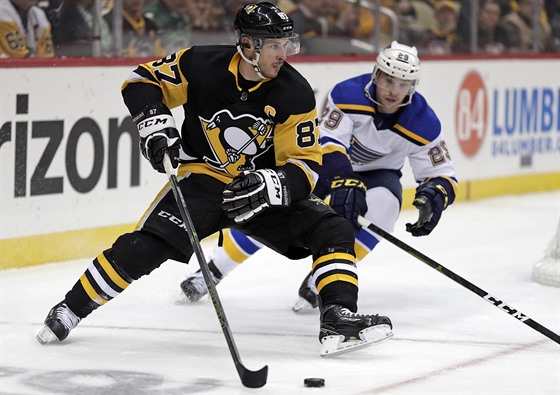Sidney Crosby z Pittsburghu (vpedu) manévruje s pukem bhem zápasu proti St....