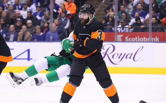 Radko Gudas z Philadelphie posílá k ledu Zacha Hymana z Toronta.