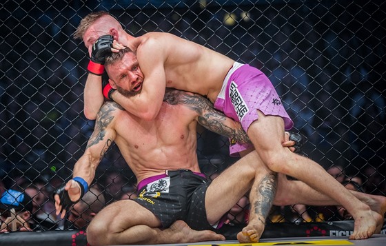 MMA zápasník David Kozma (rové trenky) drí pod krkem Samuela Kritofie.