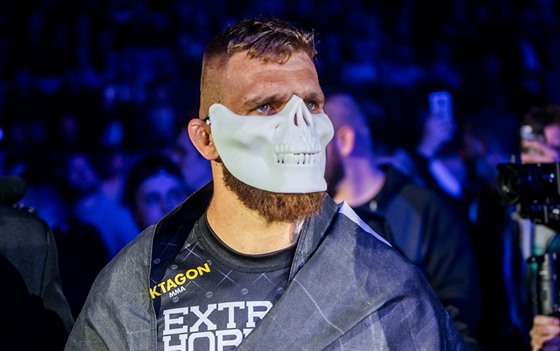 Slovenský zápasník MMA Samuel Kritofi nastupuje do zápasu s bílou maskou.