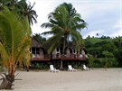 Na Cookových ostrovech rostou palmy místy pímo skrze pláové bungalovy.