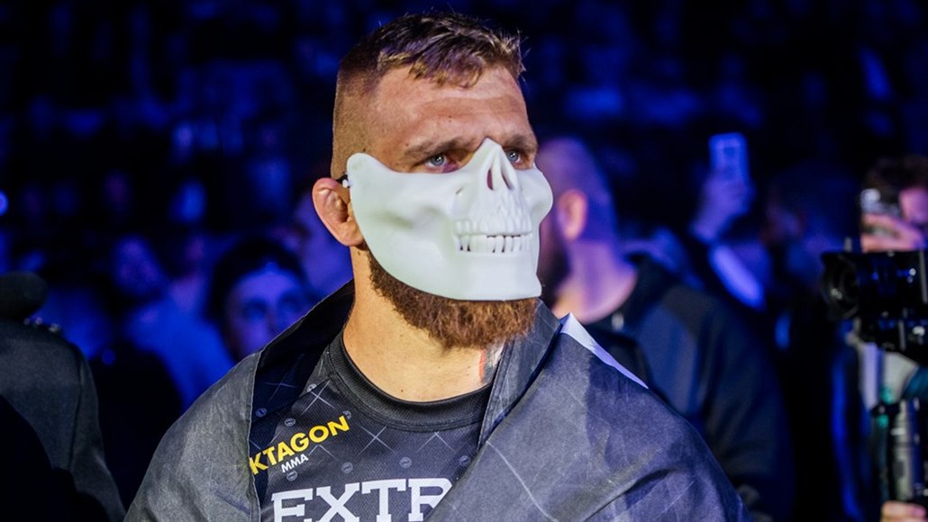 Slovenský zápasník MMA Samuel Kri�tofi� nastupuje do zápasu s bílou maskou.
