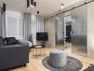 Obývací pokoj pro Andreu pojali designéři převážně v šedé, černé a antracitové...