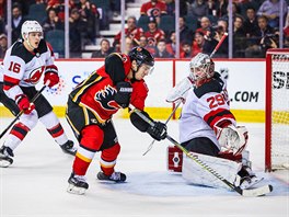 Johnny Gaudreau z Calgary se pokou pelstt branke New Jersey Mackenzieho...