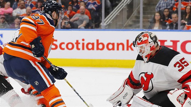 Connor McDavid z Edmontonu ped brankou New Jersey. Ve stehu je brank Cory Schneider