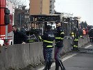 Hasiči a policisté u zbytků vyhořelého autobusu v italském San Donato Milanese....