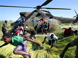 NOUZOVÉ BALÍKY. Lidé vykládají z helikoptéry Jihoafrických obranných sil...