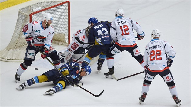 Hokejisté Kladna a Chomutov bojují o puk vedle brankáře Justina Peterse.