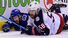 Hokejista Tyler Motte (vlevo) z Vancouveru le�í na zemi vedle Davida Savarda z...