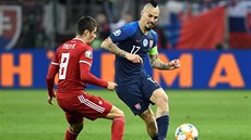 Slovenský kapitán Marek Ham�ík brán�ný Adamem Nagym z Ma�arska.