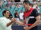 Roger Federer (vlevo) pijímá gratulace od Johna Isnera po jejich vzájemném...