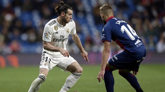 Gareth Bale z Realu Madrid (vlevo) se sna pelstt Jorgeho Pulida z Huescy.