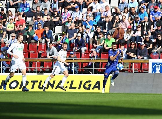 Jakub Yunis z Olomouce (vpravo) spchá za balonem, ohlíejí se za ním karvintí...