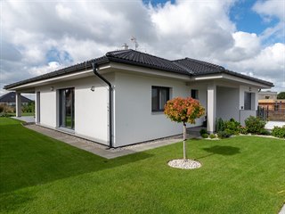 Přesah střechy i hmota garáže tvoří kolem hlavního vstupu závětří chránící před...