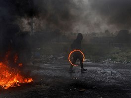 OHNIVÝ KRUH. Palestinský demonstrant drí ohnivý kruh bhem potyek s...