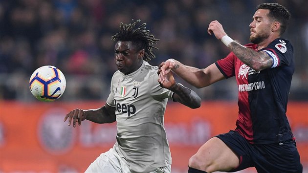 Moise Kean z Juventusu se prodr mezi fotbalisty Cagliari - vpravo Luca Ceppitelli, vlevo Fabio Pisacane.