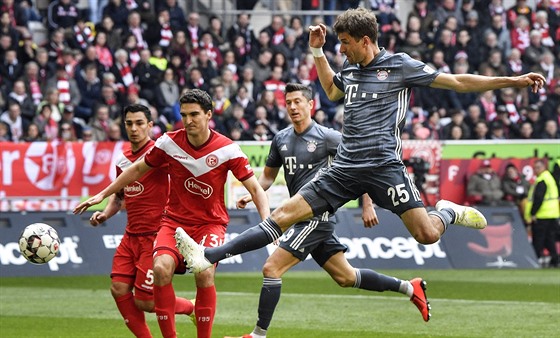 Thomas Müller z Bayernu Mnichov (v edém) skóruje v utkání s Düsseldorfem.