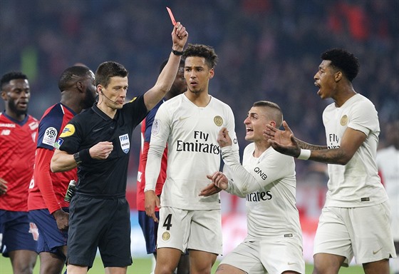 Fotbalisté PSG (v bílém) se bouí poté, co rozhodí ukazuje ervenou kartu...