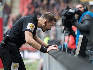 Rozhodčí Karel Hrubeš v derby mezi Slavií a Spartou zkoumá na videu penaltovou...