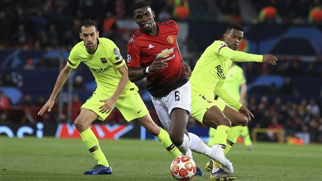 Paul Pogba (Manchester United) vede m, za nm dvojice hr Barcelony Sergio Busquets (vlevo) a Nelson Semedo.