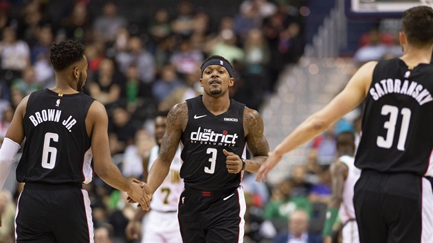 Troy Brown Jr., Bradley Beal a Tom Satoransk (zleva) oslavuj povedenou akci Washingtonu proti Bostonu.