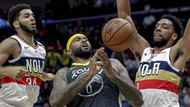 DeMarcus Cousins (uprosted) z Golden State pod tlakem Kenricha Williamse (34) a Jahlila Okafora (8) z New Orleans.