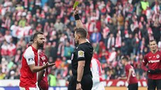 Josef Hušbauer ze Slavie (vlevo) dostává v derby se Spartou žlutou kartu za...