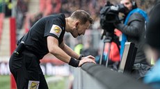Rozhodčí Karel Hrubeš v derby mezi Slavií a Spartou zkoumá na videu penaltovou...