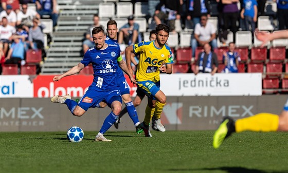 Olomoucký kapitán David Houska (v modrém) pálí v duelu s Teplicemi