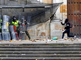 PROTESTY. Demonstrant hází kamenem po policistech pi nepokojích v kolumbijské...