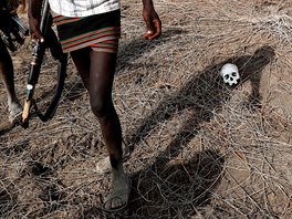 PORAENÝ. Bojovník afrického etnika Turkana míjí lebku bojovníka z kmene...