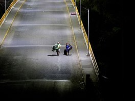 MIGRANTI. Lidé patící k migrantm z Hondurasu pichází po most do Spojených...