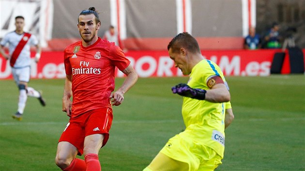 Gareth Bale z Realu Madrid (vzadu) a Alberto Garcia z Vallecana bhem zpasu panlsk ligy.