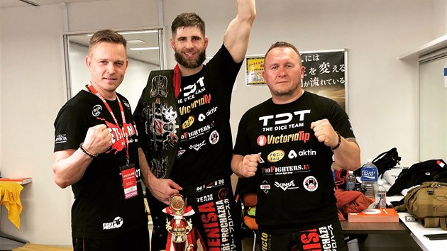 Uprostřed je MMA zápasník Jiří Procházka, po stranách jeho trenéři. Procházka získal pás šampiona japonské organizace Rizin