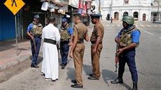 Policisté a zástupci armády na ulici diskutují s místním duchovním. (24. dubna...