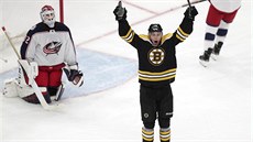 Charlie Coyle z Bostonu slaví, branká Columbusu Sergej Bobrovskij polyká...