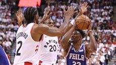 Jimmy Butler (23) z Philadelphie se tla�í kolem Kawhiho Leonarda (2) a Jodieho...