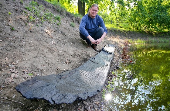 Archeolog Libor Kalík u kusu vydlabané lodi, který náhodný kolemjdoucí objevil...