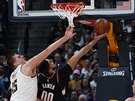 Enes Kanter (vpravo) z Portlandu se snaí zakonit pes bránícího Nikolu Jokie...