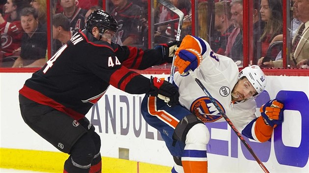 Calvin de Haan (44) z Caroliny atakuje Caseyho Cizikase z NY Islanders.