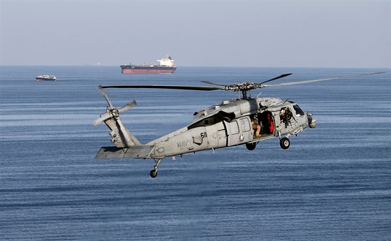 Americká helikoptéra MH-60S a Saúdský ropný tanker v pozadí v Hormuzském...