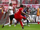 Renato Sanches z Bayernu Mnichov (v erveném) z úhlu stílí gól do sít...