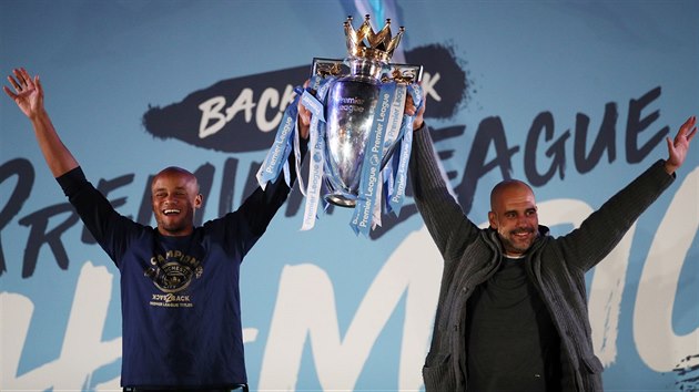 OBHJCI Z MANCHESTERU. Trenr Pep Guardiola a kapitn Vincent Kompany slav s pohrem pro vtze anglick Premier League.