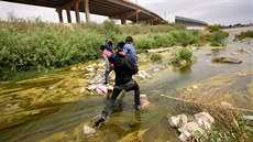 PES HRANICE. Migranti na hranici mezi Mexikem a USA se brodí pes eku Rio...