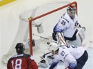 Kanadský útoník Pierre-Luc Dubois pekonává brankáe Coryho Schneidera z USA-