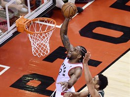 Kawhi Leonard (v blm) z Toronta zakonuje kolem Malcolma Brogdona z...