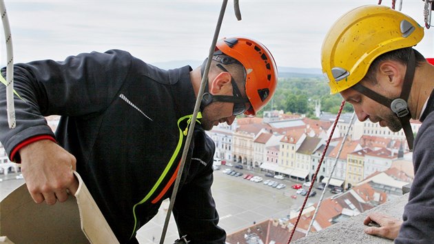 Dvojice horolezců ve čtvrtek začala s natíráním čtyř hodinových ciferníků na Černé věži v Českých Budějovicích.