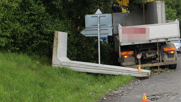 Řidič nákladního auta převážející betonové panely jel příliš rychle, jeden z nich v zatáčce z korby spadl a poničil silnici.