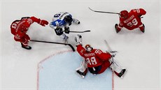 Rus Andrej Vasilevskij sbírá puk do lapa�ky, p�ed ním bojuje Fin Veli-Matti...